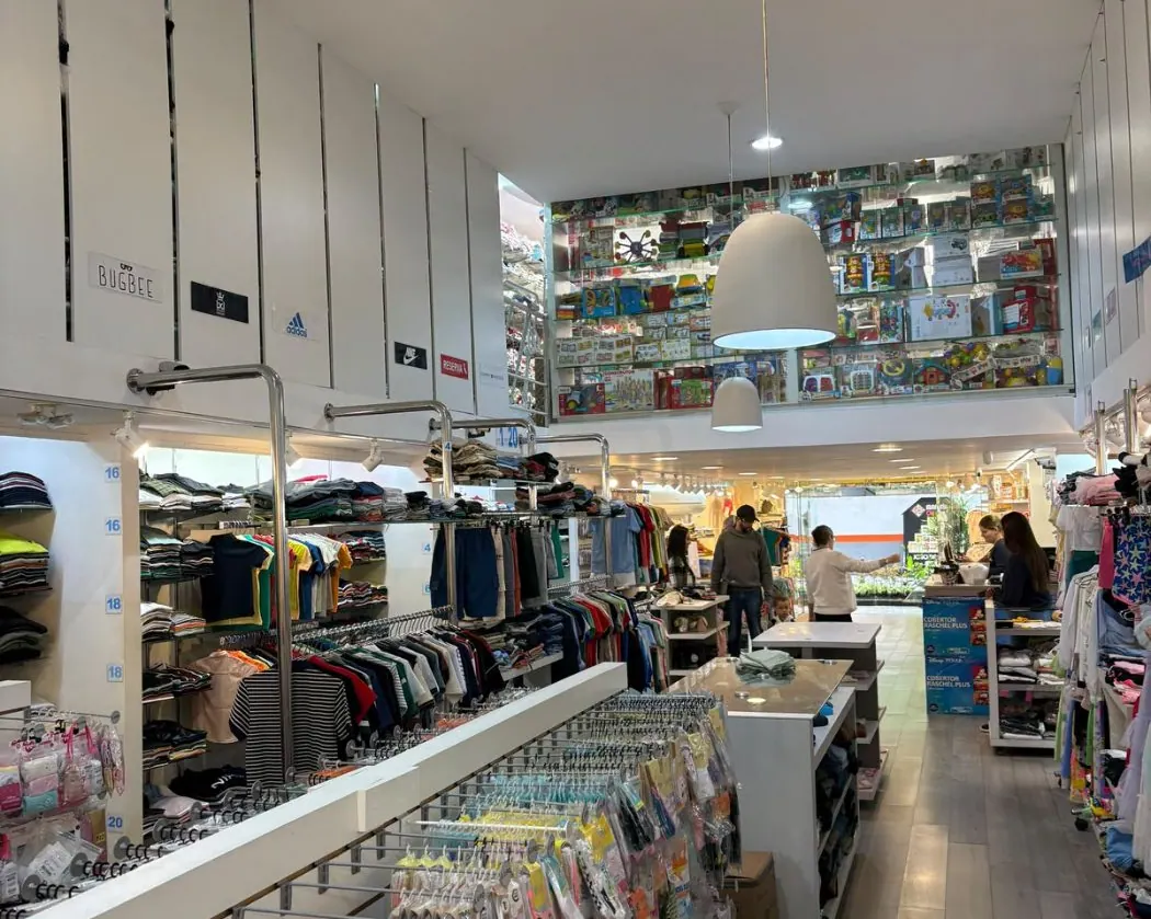 Interior da Pirulito Modas com araras de roupas infantojuvenis